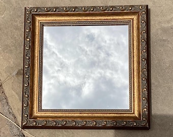 Gold framed wall mirror.  Small vintage mirror in ornate frame, square or diamond shaped.