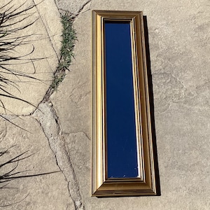 Long narrow wall mirror.  Tall vintage rectangular mirror in gold painted wood frame.