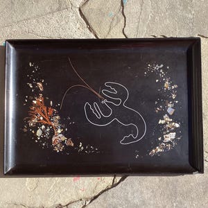 May include: A rectangular black tray with a white outline of a lobster. The tray is decorated with small pieces of shell and coral. The tray has a glossy finish and a raised edge.