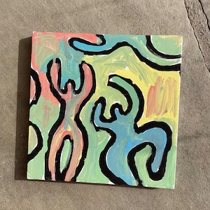 Puede incluir: Arte en lienzo cuadrado con un dise&ntilde;o abstracto. La obra presenta figuras en rosa, azul y verde, delineadas en negro, sobre un fondo amarillo y verde. La pintura est&aacute; sobre una superficie de lienzo.