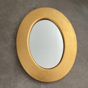 Gold framed oval mirror.  Mid sized oval wall mirror in slightly worn gold Florentine looking frame.