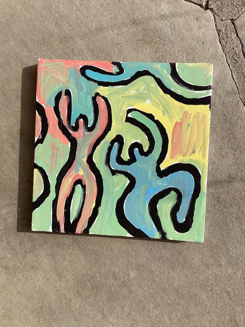 Puede incluir: Arte en lienzo cuadrado con un dise&ntilde;o abstracto. La obra presenta figuras en rosa, azul y verde, delineadas en negro, sobre un fondo amarillo y verde. La pintura est&aacute; sobre una superficie de lienzo.