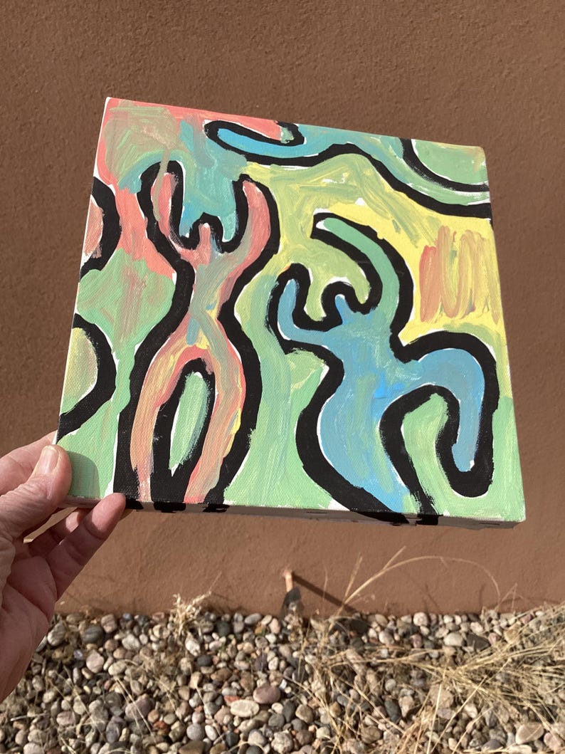 Puede incluir: Arte en lienzo cuadrado con figuras abstractas delineadas en negro. Las figuras est&aacute;n rellenas de rosa, azul y verde, sobre un fondo amarillo y verde. La obra de arte est&aacute; sostenida por una mano. La pintura es cuadrada.