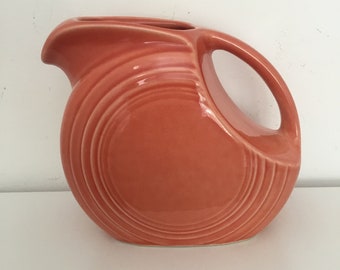 Small vintage Fiesta disk pitcher.  Small peach colored Fiesta pitcher.