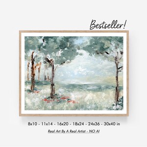 Pode incluir: Pintura de paisagem emoldurada com uma cena de floresta em tons de verde, azul e castanho. A obra apresenta árvores, um corpo de água e um céu claro. O texto "Bestseller!" está no canto superior direito. Disponível em tamanhos de 20x25 cm a 76x102 cm.