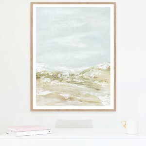 May include: A framed abstract painting with a light blue background and a landscape scene in shades of green and brown.