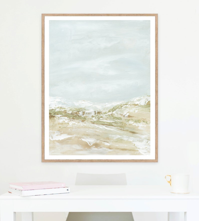 May include: A framed abstract painting with a light blue background and a landscape scene in shades of green and brown.