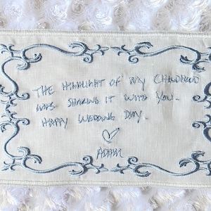 Une écriture manuscrite pour ceux que vous aimez est utilisée pour créer une broderie sur une étiquette de robe de mariée personnalisée.