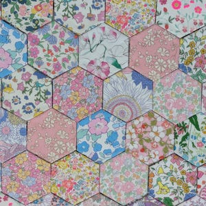 May include: A collection of hexagonal fabric patches arranged in a honeycomb pattern, each featuring distinct floral prints in various colours including pink, blue, yellow, green, and white, creating a dense mosaic of diverse botanical patterns.