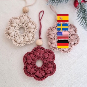 May include: Three handmade crochet flower ornaments in beige, mauve, and burgundy. Each has a central hole and a wooden bead at the top. The ornaments are designed for hanging and add a touch of handmade charm to any space.