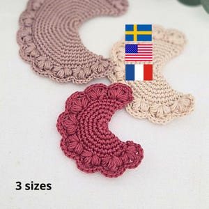 May include: Close-up of three crocheted, crescent-shaped pieces in varying shades of pink and beige. Each piece has a scalloped edge with a floral pattern. The text "3 sizes" is visible at the bottom.