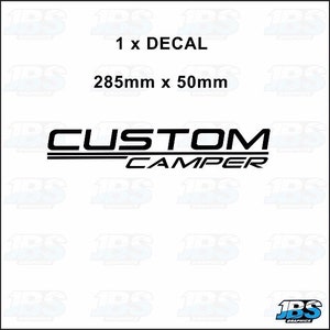 May include: Black decal with the text "CUSTOM CAMPER" in a bold, modern font. The decal measures 28.5cm x 5cm. The word "CUSTOM" is above the word "CAMPER".