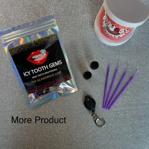 May include: A close-up of a clear plastic bag with a black label that reads "Icy Tooth Gems and Teeth Whitening The Glamorous Life!" The bag contains a variety of small items, including tooth gems, applicators, and a small flashlight. There are also two small black containers and four purple applicators on a silver sparkly surface.