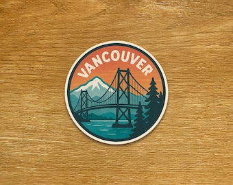 May include: Circular sticker with a scenic illustration of a bridge over water, mountains, and evergreen trees. The word "VANCOUVER" is printed in a circular design. The sticker has a retro, outdoorsy aesthetic.