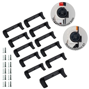 May include: Ten black plastic wall mounts with screw holes, designed to hold Lego sets. The mounts are arranged in two rows of five. A set of screws is included. The image also shows a close-up of a Lego McLaren Solus GT set with the text "76*** Numbered Sets".