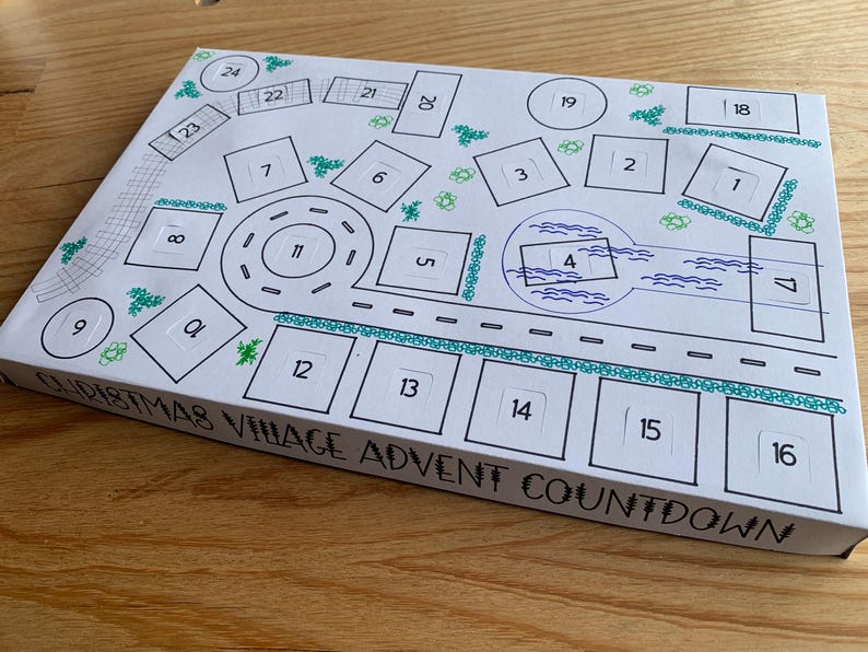 K&ouml;nnte beinhalten: Eine wei&szlig;e Weihnachtsdorf-Adventskalender-Box mit einem handgezeichneten Dorfdesign. Das Design umfasst nummerierte K&auml;stchen, Stra&szlig;en und dekorative Elemente. Der Text "CHRISTMAS VILLAGE ADVENT COUNTDOWN" ist sichtbar.