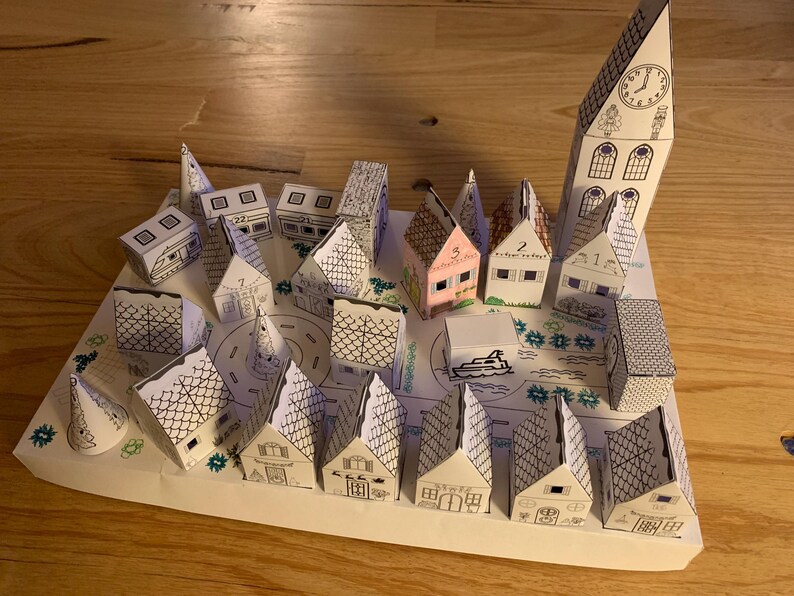 K&ouml;nnte beinhalten: Ein handgefertigtes Papiermodell einer Stadt mit vielen kleinen H&auml;usern, einem Kirchturm mit Uhr und einer zentralen Stra&szlig;e. Die H&auml;user sind wei&szlig; mit schwarzen Umrissen, einige mit rosa oder grauen D&auml;chern. Die Szene ist auf wei&szlig;em Papier gezeichnet.