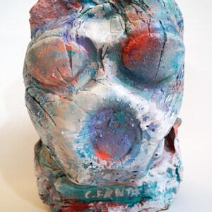 Puede incluir: Una taza de cerámica blanca con un asa negra y el texto "But First, Coffee" en un estilo manuscrito. La taza está sobre una superficie blanca. La taza mide aproximadamente 10 cm de alto.