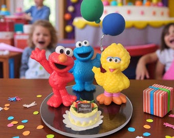May include: A birthday scene featuring Elmo, Cookie Monster, and Big Bird figurines. A small cake with a "Happy Birthday" sign sits in front of the characters. Colorful confetti and a wrapped gift box add to the festive atmosphere. Balloons and a birthday cake are in the background.