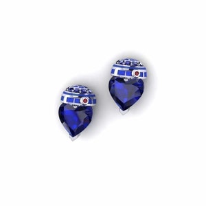 May include: A pair of silver heart-shaped earrings with a blue sapphire stone and a blue and white enamel R2-D2 design on top.