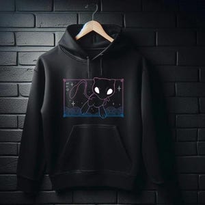 May include: Black hoodie featuring a graphic of a white silhouette of a Pokemon character against a blue and pink galaxy background.