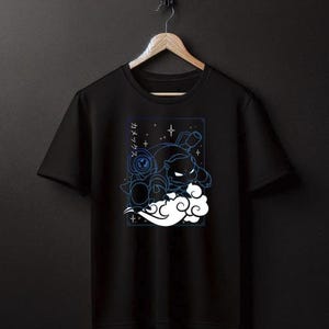 May include: Black t-shirt featuring a blue and white graphic print of a cartoon character in a cloud with stars and Japanese text.