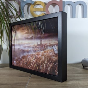 Cadre lumineux noir affichant une scène de prairie brumeuse tirée du jeu Elden Ring, parfait pour décorer une pièce de jeu. Vue de profil, idéal comme cadeau pour les fans d'Elden Ring.