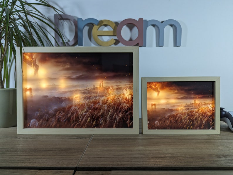 petit cadre lumineux led d'Elden Ring avec l'Erdtree, encadrement clair sur un bureau, à côté d'une plante et d'une manette, créant une ambiance de jeu immersive.