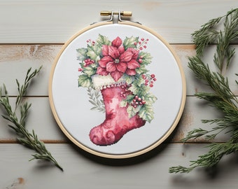 May include: A red Christmas stocking with a white cuff is filled with a poinsettia flower and green foliage. The stocking is in a wooden embroidery hoop.