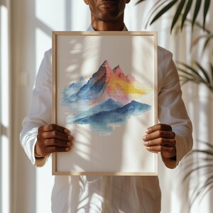 May include: A framed watercolor painting of a mountain range with a colorful gradient of pink, yellow, blue, and green. The mountains are depicted in a stylized, abstract style.
