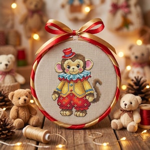 May include: A cross-stitch embroidery hoop featuring a cartoon monkey in a circus outfit. The monkey wears a red top hat, a blue and white ruffled collar, and a yellow jacket. The hoop is decorated with red and gold ribbon, and surrounded by teddy bears and fairy lights.