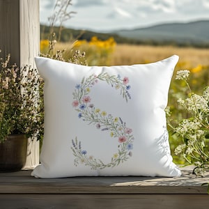 Peut inclure: Panneau en bois fait à la main avec le texte "Bienvenue" dans une police fantaisiste. Le panneau est peint en blanc avec une finition vieillie et présente un motif floral dans les tons de rose et de vert. Il mesure environ 30 cm de large.