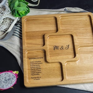 May include: A wooden serving tray with six compartments, engraved with the text "M&J" and a recipe for "Mielestys Recipe".