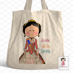 May include: A white tote bag with a cartoon illustration of a woman wearing a red dress and a sash with the Spanish flag. The text "Jo sóc de la Terreta" is printed on the bag.