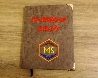 A weekly Planner with custom monogram and embroidered flag for 2024 year.