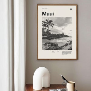 Puede incluir: Fotografía en blanco y negro de una escena de playa con palmeras y una costa rocosa. El texto "Maui" está impreso en letras blancas en negrita en la parte superior de la imagen. Las coordenadas "20°48'N 156°18'W" están impresas en letras blancas más pequeñas encima del texto "Maui".