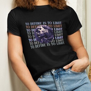 Könnte beinhalten: Ein schwarzes T-Shirt mit einem grafischen Aufdruck eines Gesichts und dem Text "To define is to limit", der mehrmals übereinandergelegt wiederholt wird.