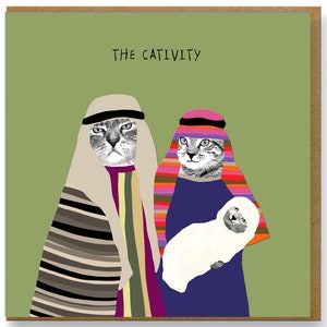 May include: Greeting card with the text "THE CATIVITY" on a green background. The card features a humorous illustration of two cats dressed in religious attire, with one holding a white lamb. The card is in a brown frame.