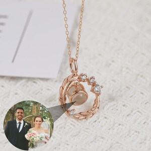 Puede incluir: Un collar de oro rosa con un colgante circular que presenta un peque&ntilde;o inserto para fotos y un delicado dise&ntilde;o de hojas. El colgante est&aacute; acentuado con peque&ntilde;as piedras de circonita c&uacute;bica transparentes.