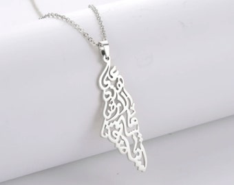 May include: A silver necklace with a pendant featuring intricate Arabic calligraphy. The pendant is shaped like a teardrop and hangs from a delicate chain.