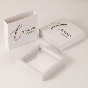 May include: Three white boxes with a clear plastic window. The boxes are labeled "Camden Customs" with a stylized "C" logo.