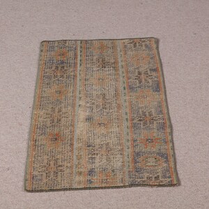 May include: A vintage style rug with a geometric pattern in shades of brown, blue, and orange. The rug has a rectangular shape and is approximately 2 feet by 3 feet.