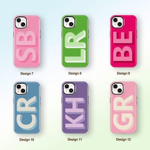 Peut inclure: Six coques de téléphone colorées sont présentées, chacune avec un design différent. Les coques affichent les lettres SB, LR, BE, CR, KH et GR dans une police en gras en 3D. Les coques sont roses, vertes, rouges, bleues, violettes et rose clair.
