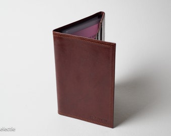 May include: A brown leather wallet with a stitched edge and the text "Le Tanneur" embossed on the front.