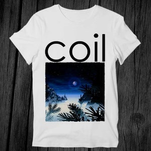 Puede incluir: Camiseta blanca con un gráfico negro de la palabra "coil" y un paisaje nocturno con una luna y árboles.