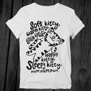 May include: White t-shirt with a black and white illustration of a sleeping cat. The text reads "Soft kitty, warm kitty, little ball of fur. Happy kitty, Sleepy kitty. purr, purr, purr."