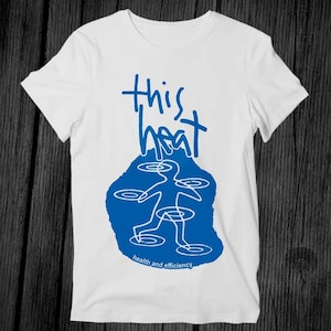 May include: White t-shirt with a blue graphic design. The design features the words "this heat" above a stylized figure with circular elements, and the text "health and efficiency" below.
