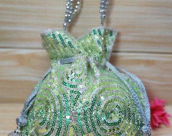 May include: A green and silver sequined drawstring bag with a silver chain strap and tassel. The bag has a swirling pattern.