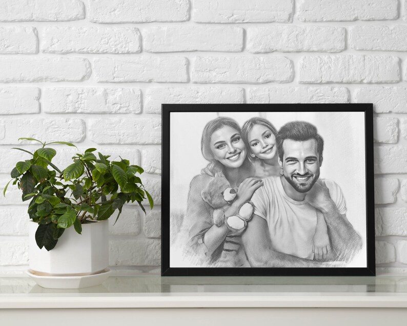 May include: A black and white pencil drawing of a family portrait. A woman, a girl, and a man are smiling and looking at the camera. The woman is holding a teddy bear. The drawing is framed in a black frame.