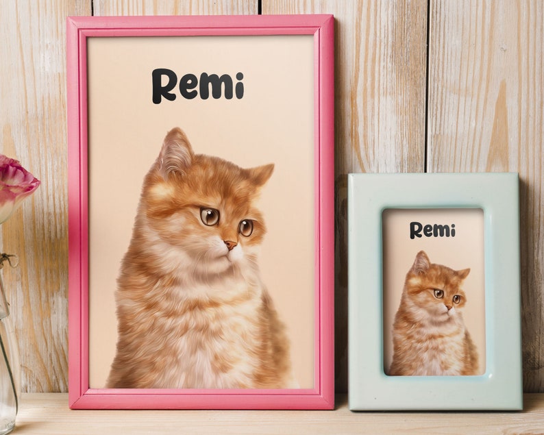K&ouml;nnte beinhalten: Zwei gerahmte Bilder einer Katze namens Remi. Der gr&ouml;&szlig;ere Rahmen ist rosa und der kleinere Rahmen ist hellblau.